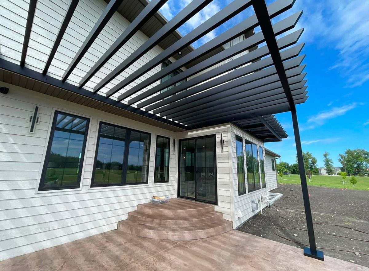 Looking up at the slat pattern of a custom aluminum pergola on a new build