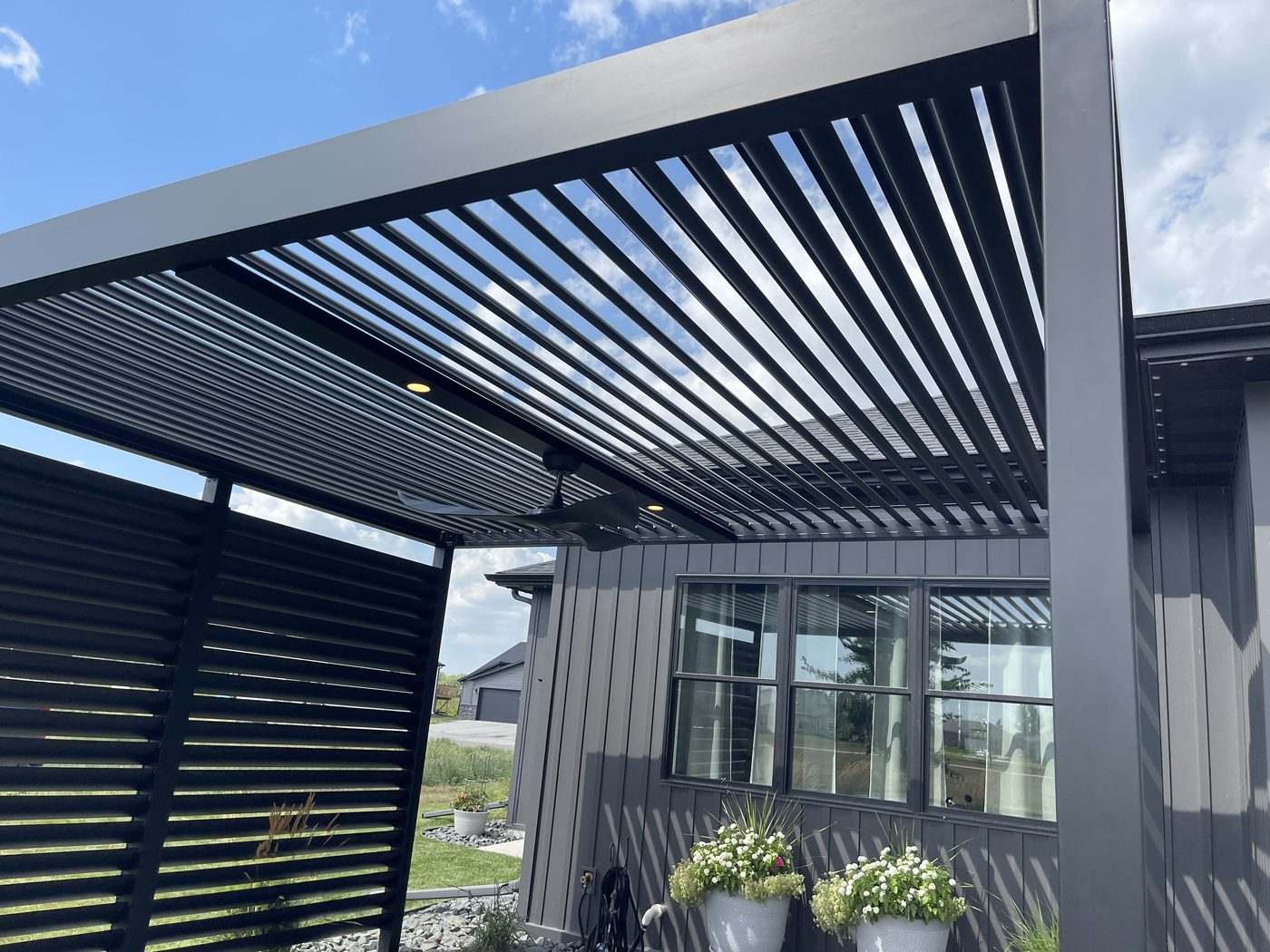 Looking up through open aluminum louvers at blue sky